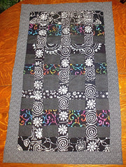 black batik and calico quilted insulated table runner with a splash of color