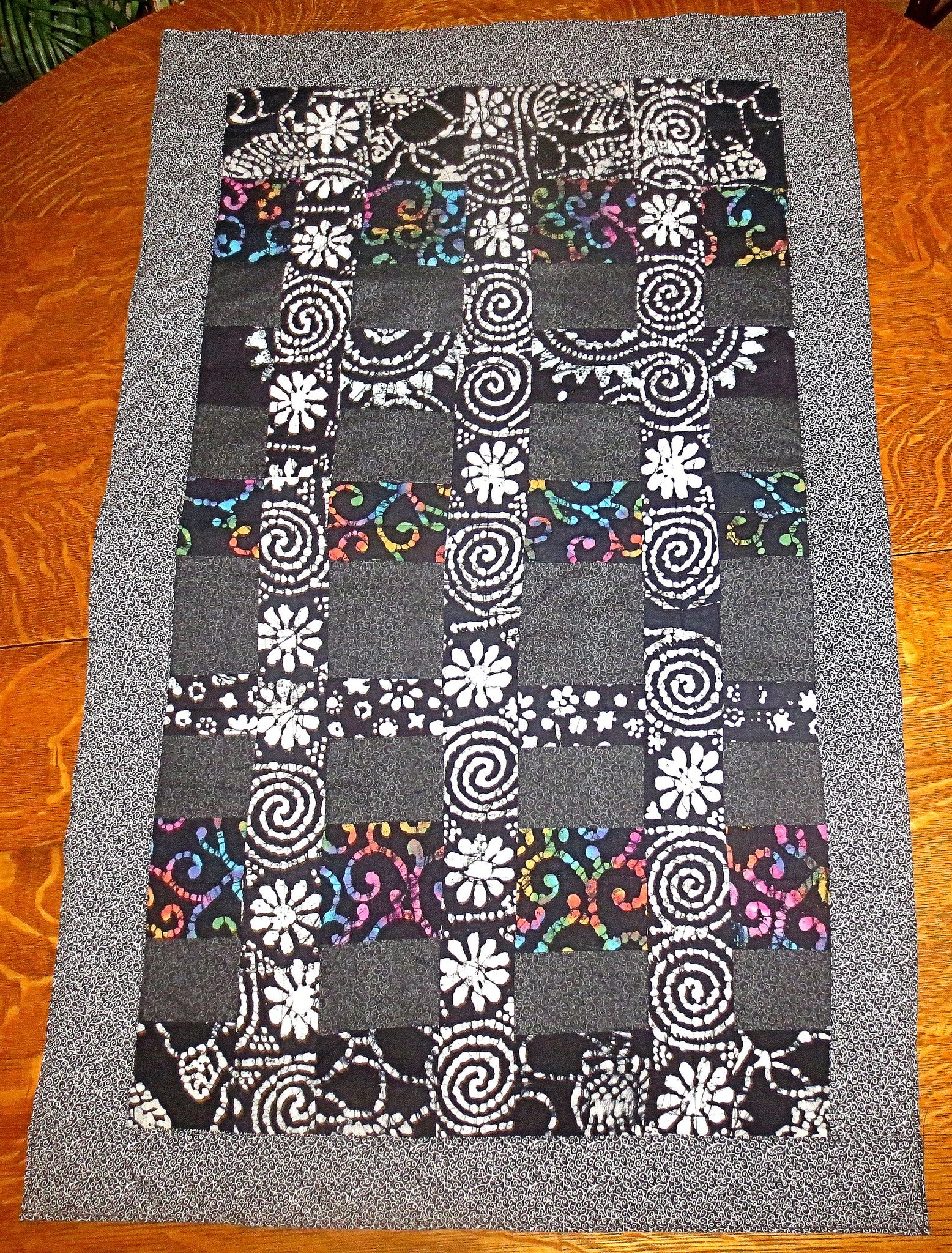 black batik and calico quilted insulated table runner with a splash of color