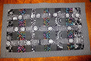 black batik and calico quilted insulated table runner with a splash of color