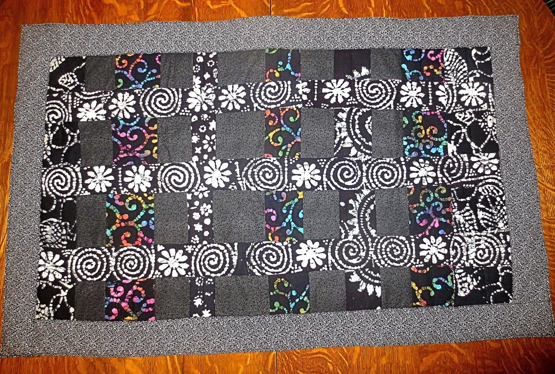 black batik and calico quilted insulated table runner with a splash of color