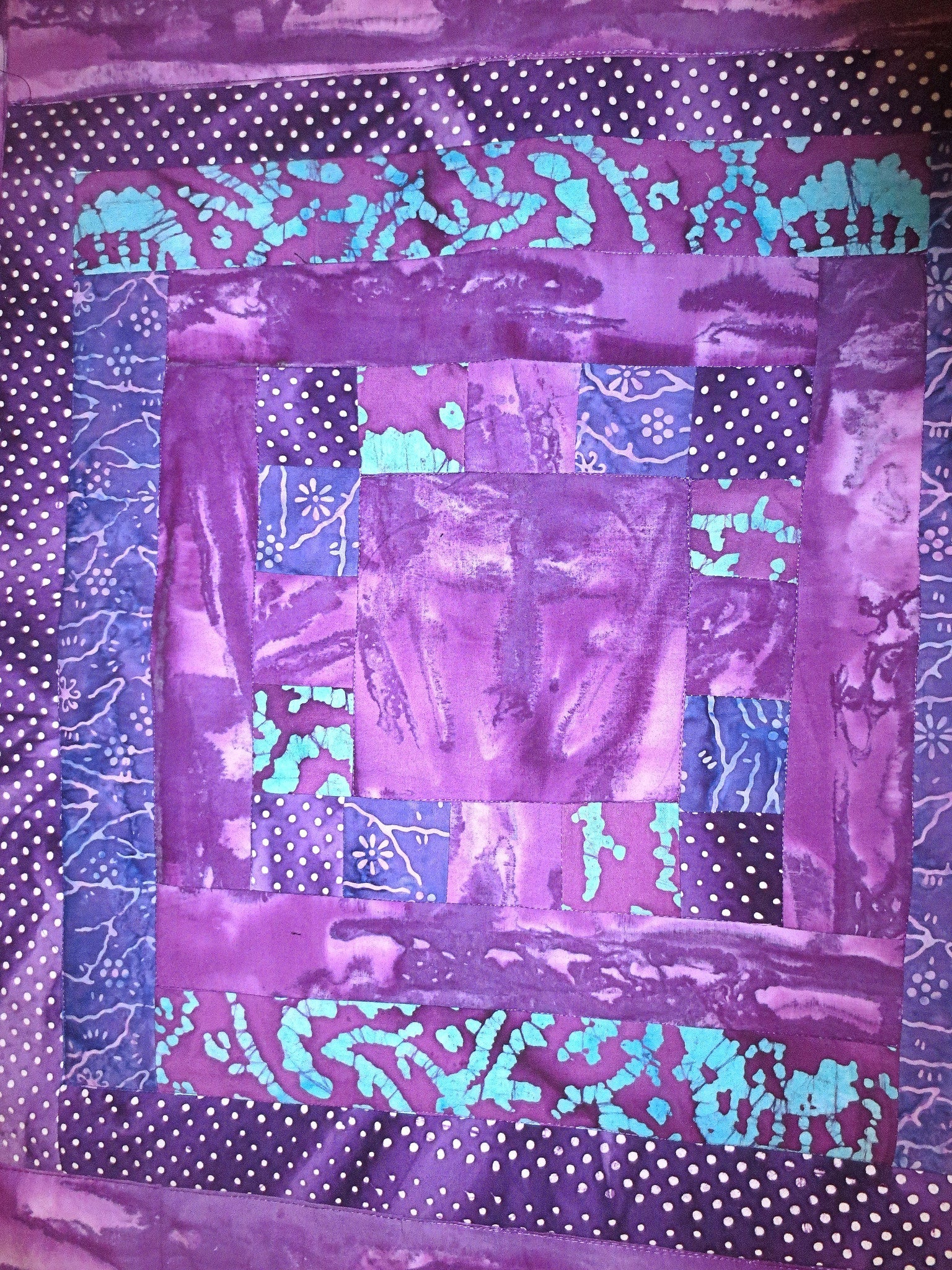 all purples batiks quilted insulated log cabin table runner with a splash of color