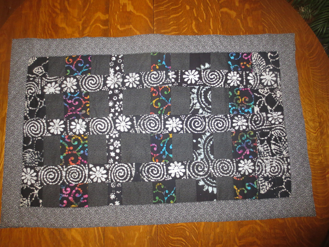 black batik and calico quilted insulated table runner with a splash of color