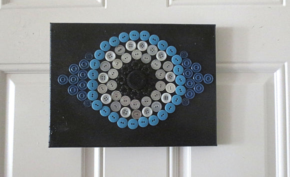 evil eye button art work with vintage buttons on canvas