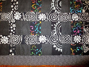 black batik and calico quilted insulated table runner with a splash of color
